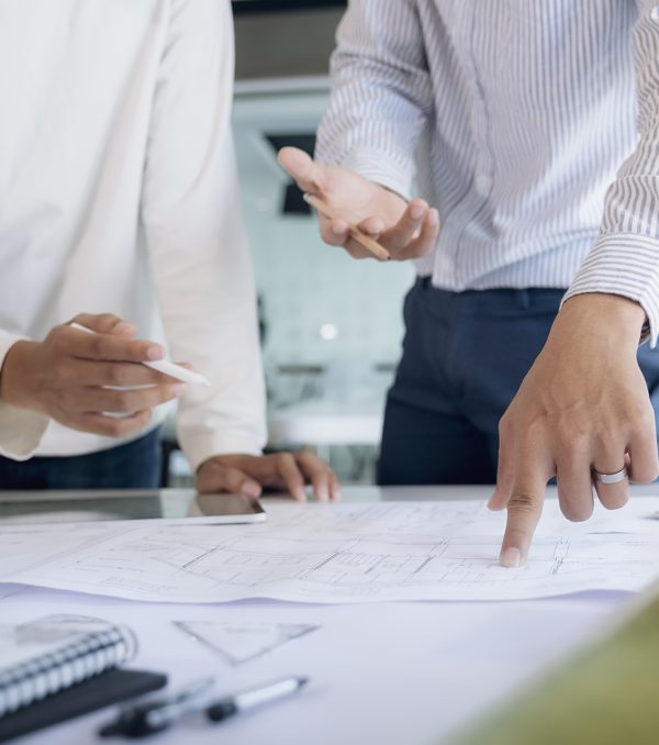 Image of engineer meeting for architectural project working with partner and engineering tools on workplace.