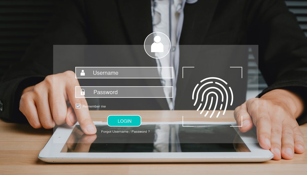Person hand typing on digital tablet with login and password and fingerprint on screen display, cyber security concept, data protection and secured internet access.